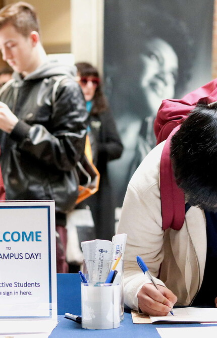 Student registering at a table for Fall Campus Day.