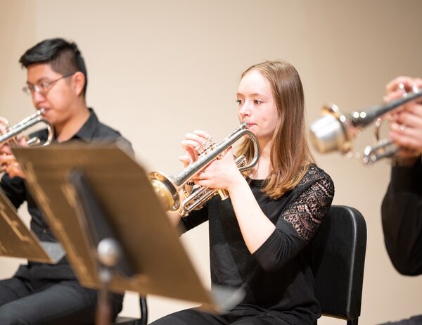 Charlotte McIntosh performs with an orchestral trumpet section.