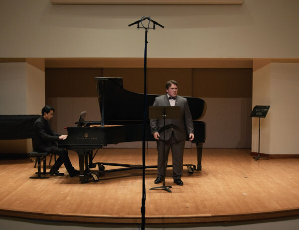 Bennett Luo performs at the piano with a male singer, in a Student Composer's Concert in Walter Hall