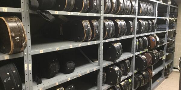 Violins stored on shelving in the Instrument Room