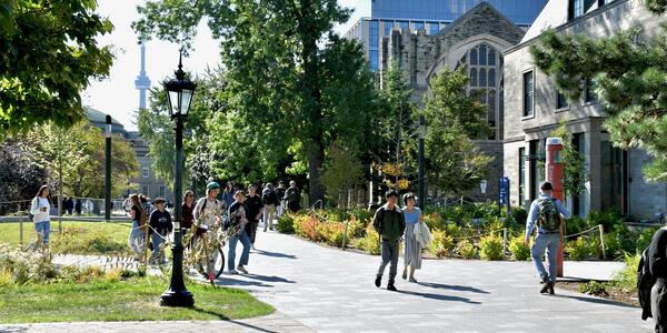 People walking on campus between a mix of historic and modern-style buildings.
