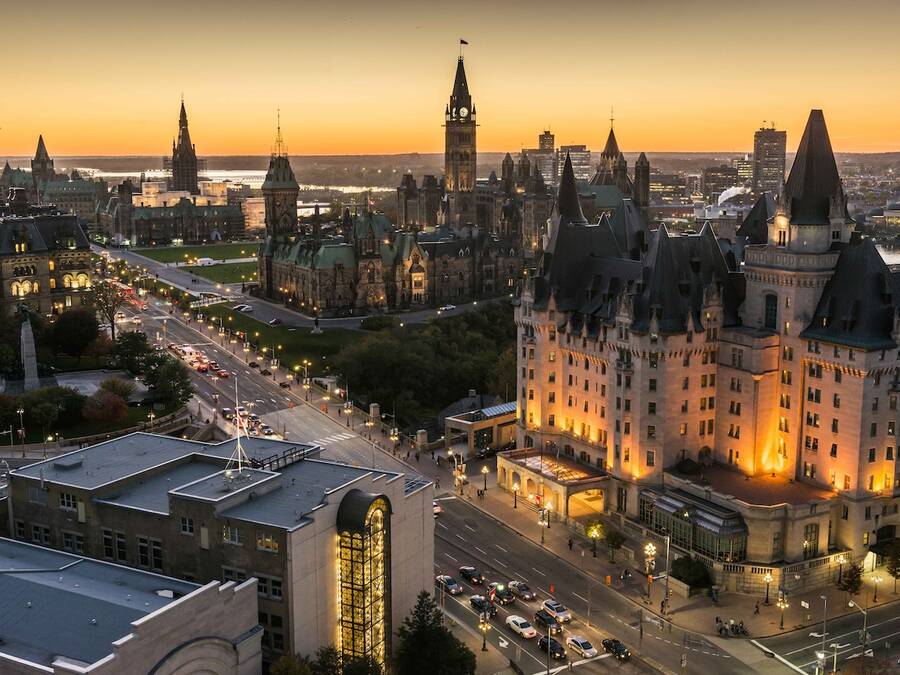 Downtown Ottawa street at dusk, illuminated by warm, glowing streetlights, with buildings and a peaceful evening ambiance in the background.