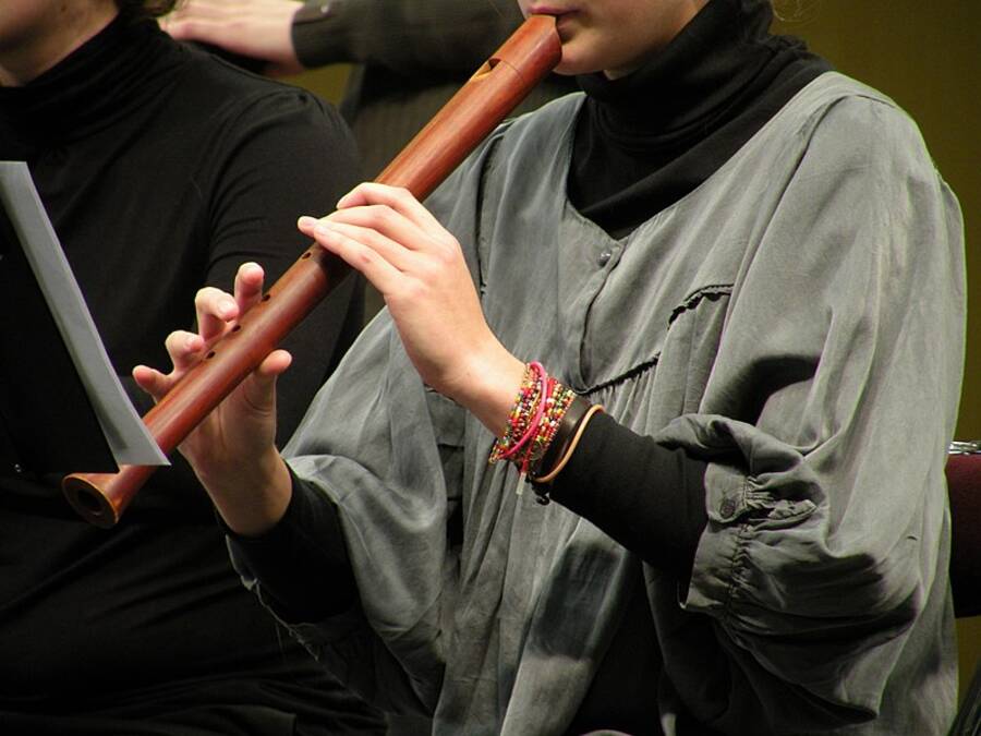 Close up of performers hands on a wooden recorder.