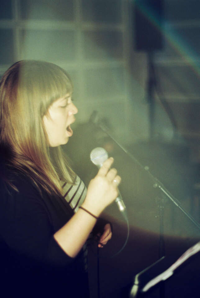 Side profile of Laura Swankey singing into a mic