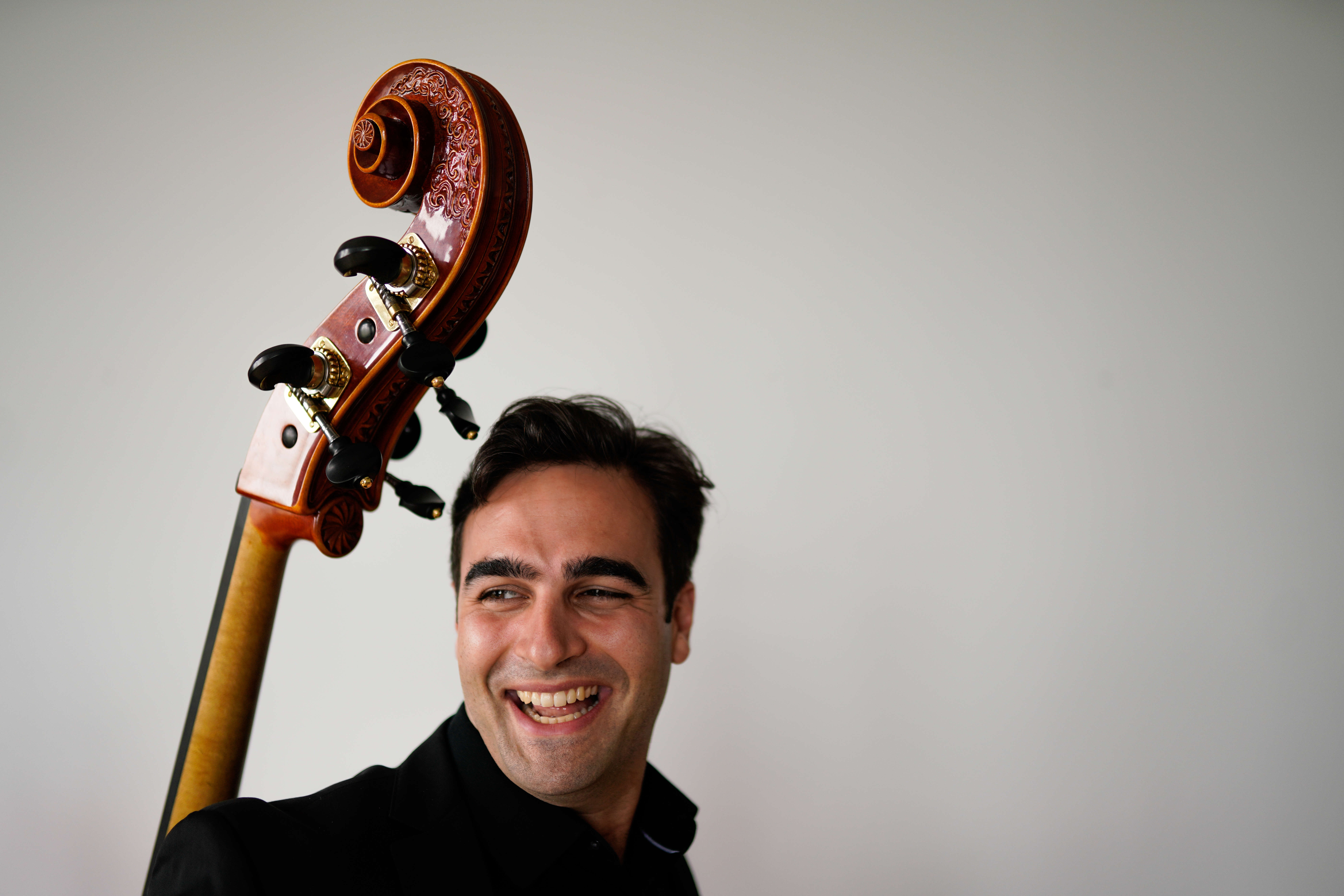 Headshot of Travis Harrison with instrument on left.