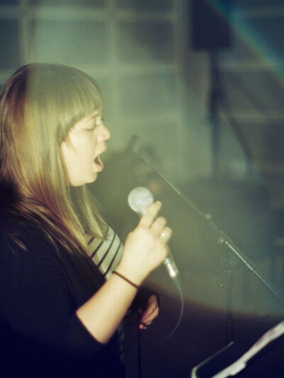 Side profile of Laura Swankey singing into a mic