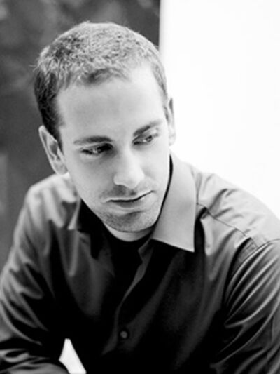 Black and white headshot of a person wearing a button-up shirt, looking to the side.