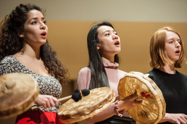 Women performing indigenous music, each with a handheld frame drum