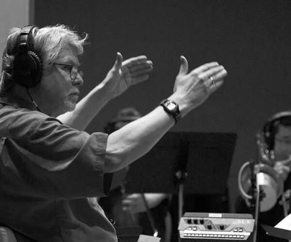 black and white photo of a person conducting an ensemble