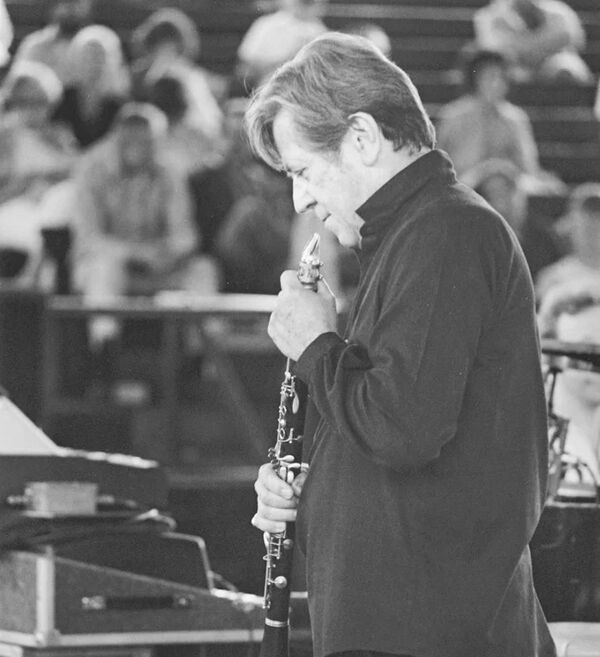 Black and white photo of person preparing to play a clarinet in front of an audience