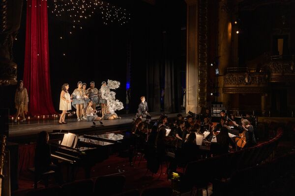 Musicians in the orchestra pit and actors on stage during an opera performance.