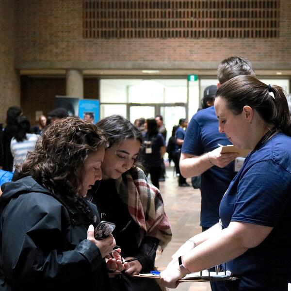 A member of the Faculty of Music staff provides information to a parent and student at Fall Campus Day.