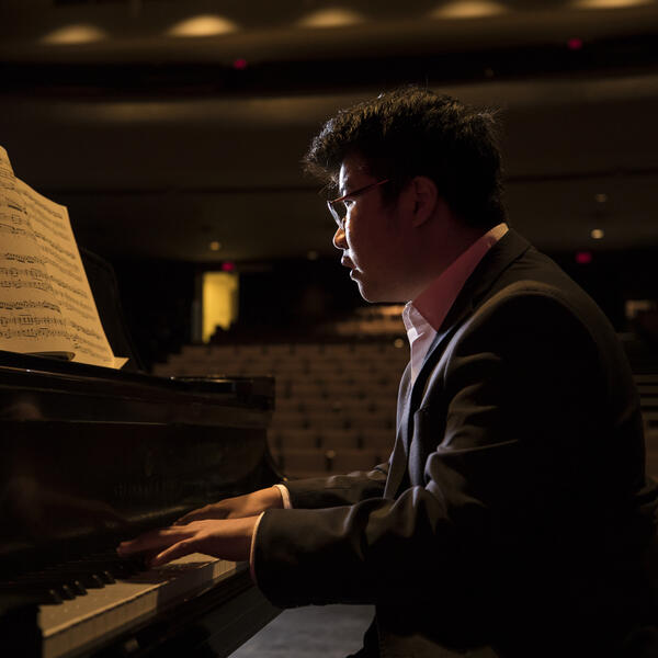 Pianist performing on stage with view out to auditorium