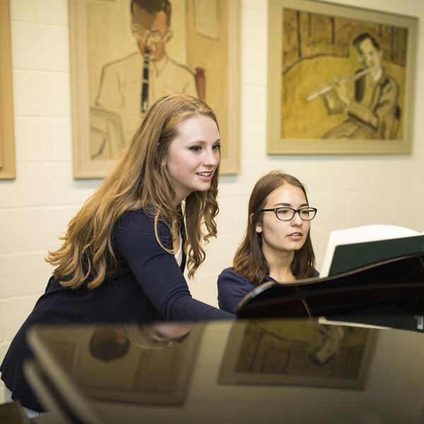 U of T Music students work together at a piano.