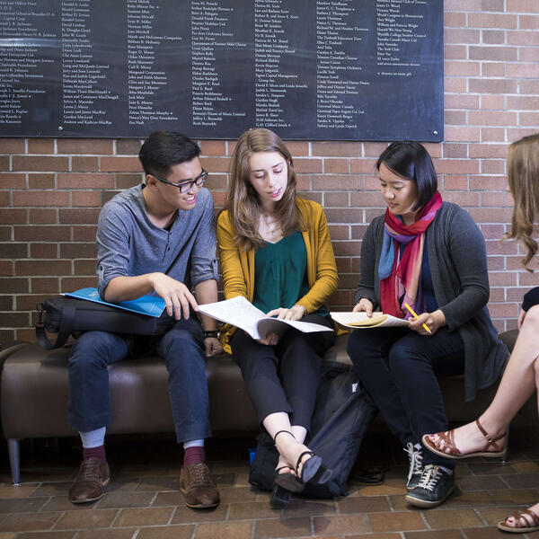 Students studying on a bench.