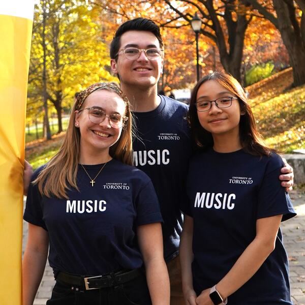 A group of three U of T Music Student Ambassadors pose for a picture together on Philosopher's Walk, just outside of the Edward Johnson Building.