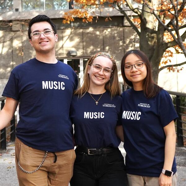 A group of three U of T Music Student Ambassadors pose for a picture together on Philosopher's Walk, just outside of the Edward Johnson Building.